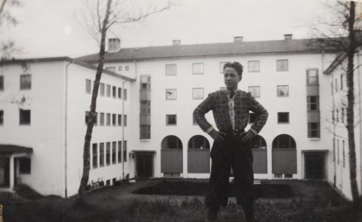 Hans Kristian poserer foran Trondarnes Folkehøgskole ved Harstad, skoleåret 1949/1950. (Fotograf ukjent).